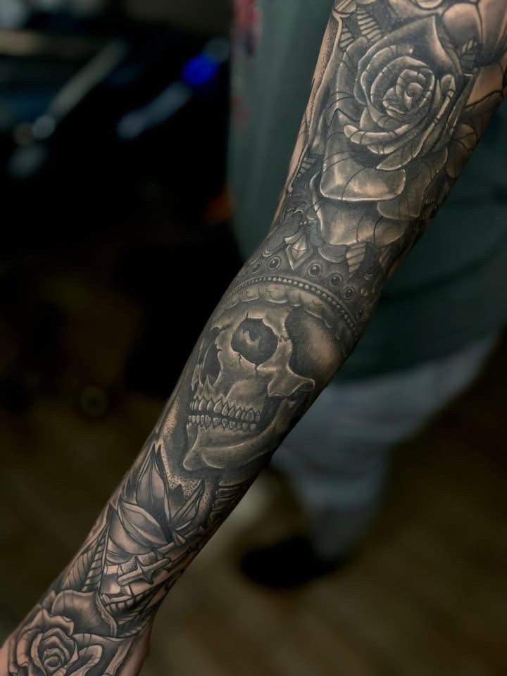Black and grey skull, rose, and crown blackwork tattoo by Clayton