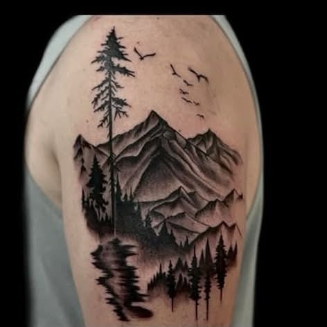 Blackwork mountain and pine forest landscape shoulder tattoo by Clayton