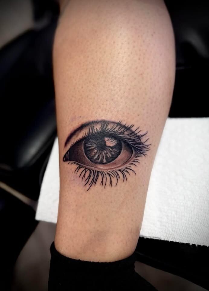 Photorealistic human eye calf tattoo by Sean